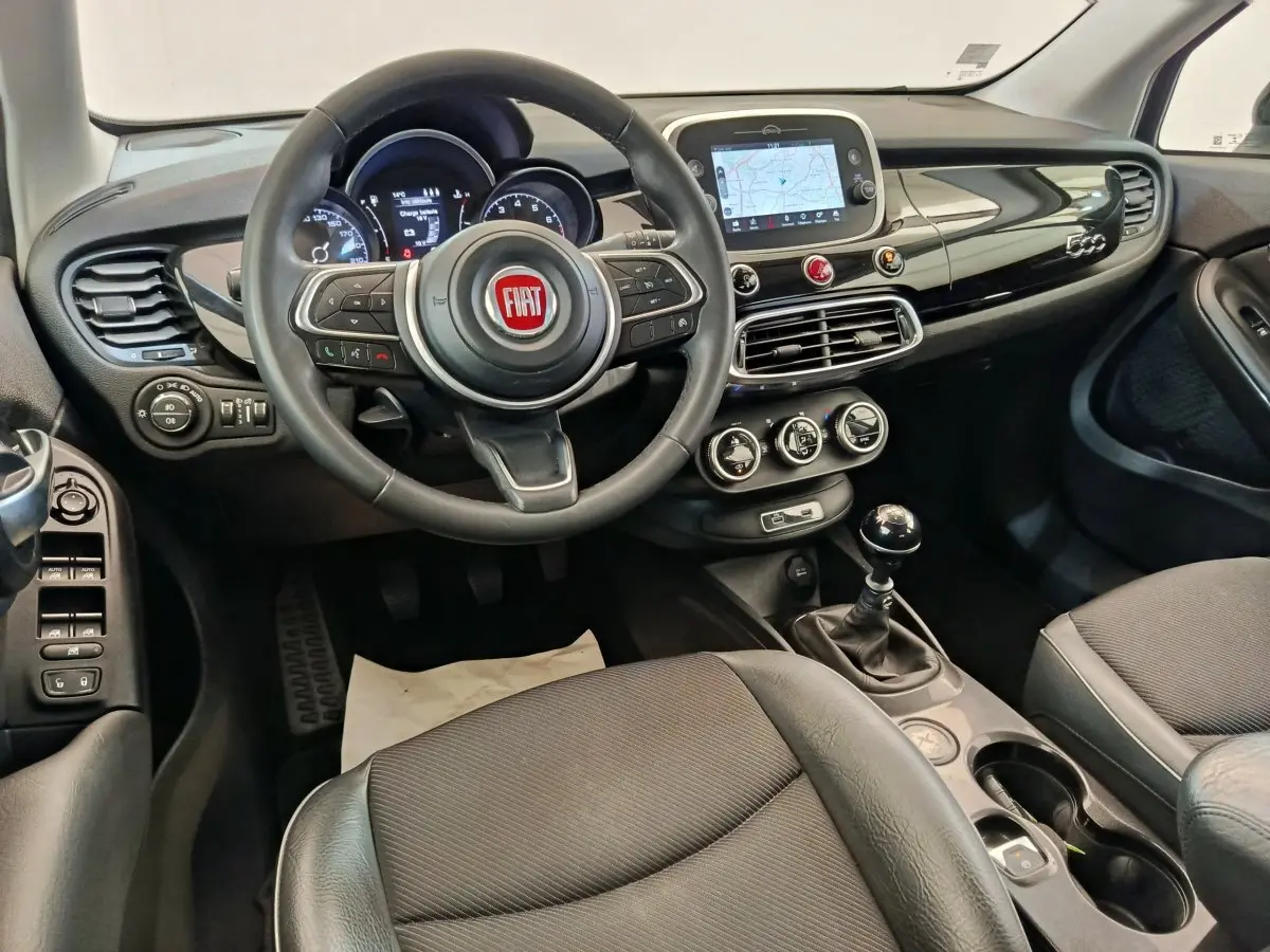 Vue intérieure avant de la Fiat 500X 2020 avec tableau de bord noir, volant multifonctions et écran tactile central.