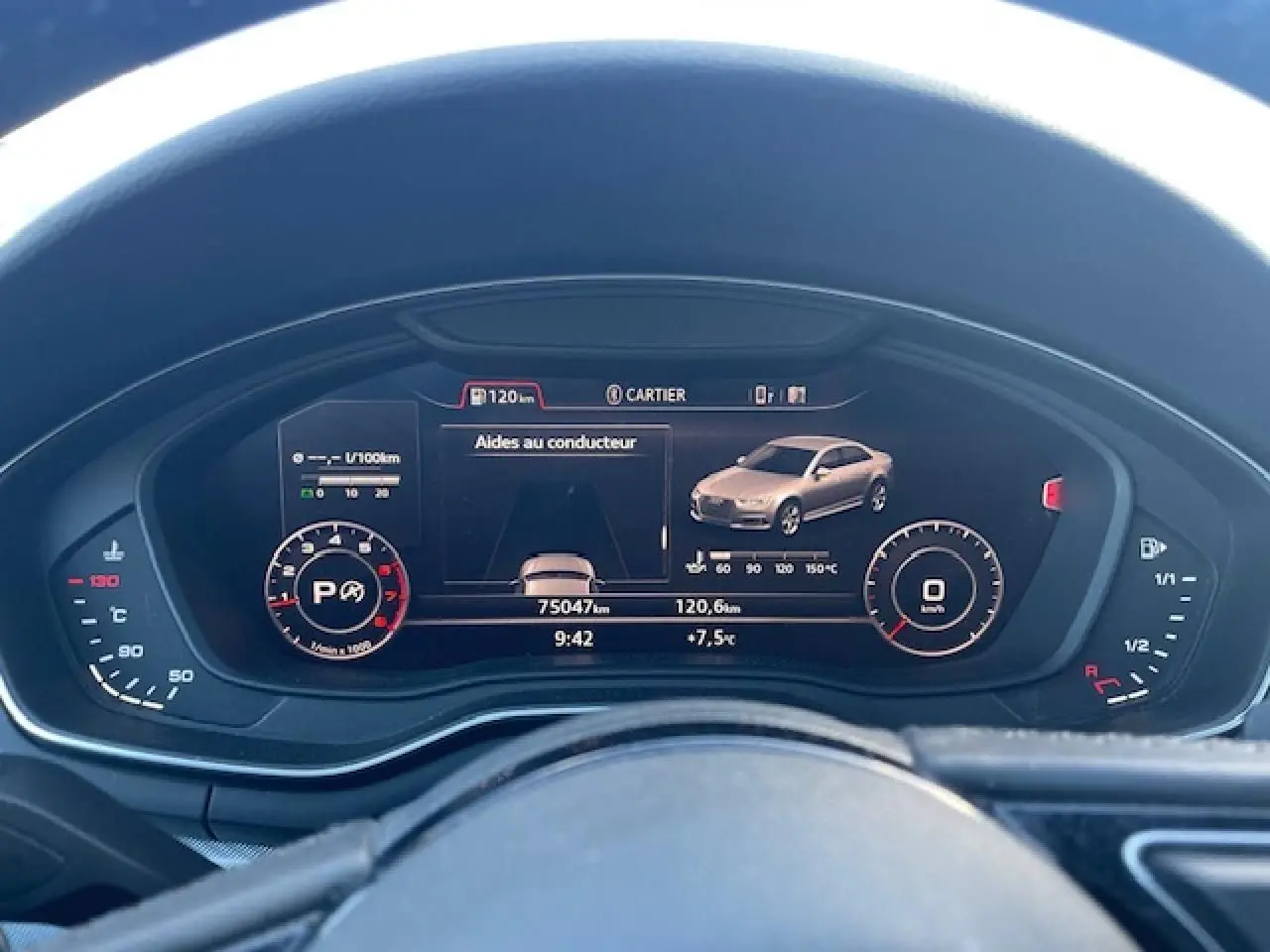 Tableau de bord numérique d'une Audi A4 argent, affichant aides au conducteur et compteurs à 9h42.