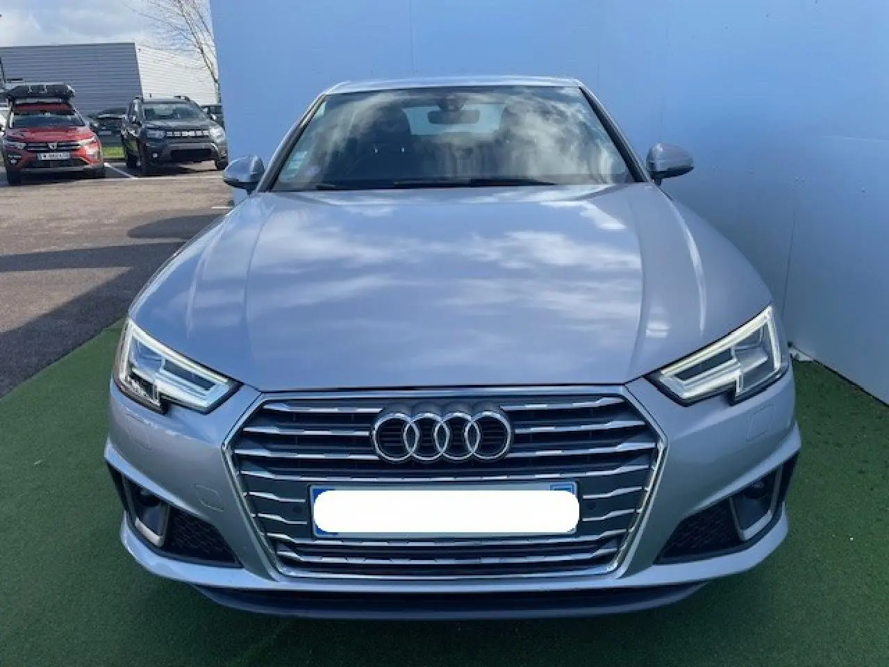 Vue frontale d'une Audi A4 argent fleuret métal 2019 avec calandre hexagonale et phares LED anguleux.