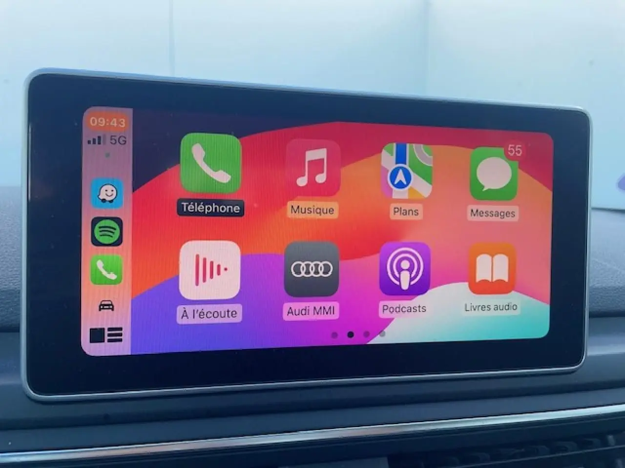 Écran tactile central de l'Audi A4 2019 affichant l'interface Apple CarPlay colorée sur fond noir.