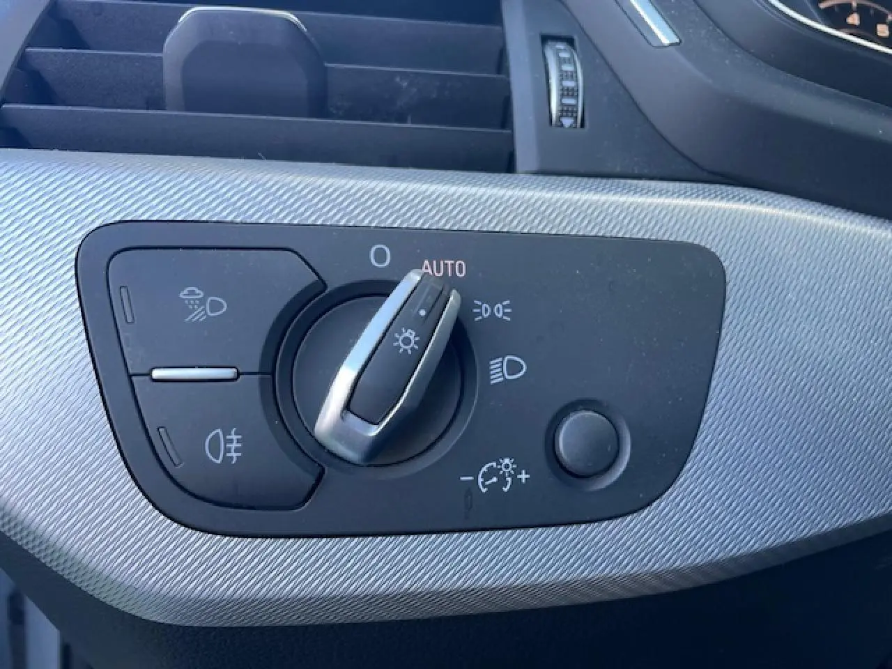 Gros plan sur la commande d'éclairage argentée à motifs diagonaux de l'Audi A4 V 35 TFSI S Line 2019.