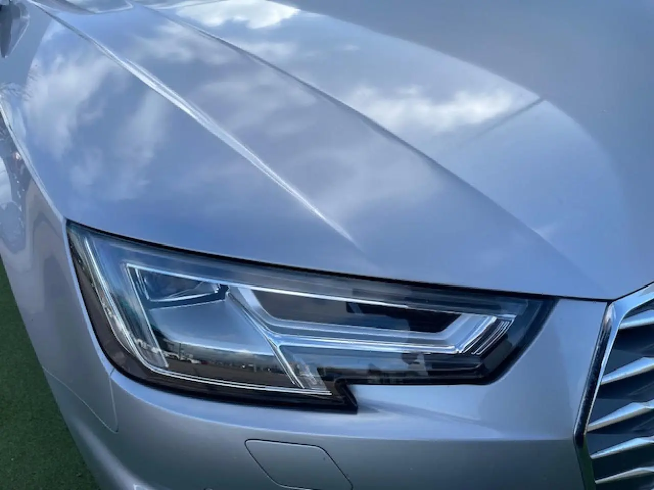 Gros plan sur le phare avant droit d'une Audi A4 2019 argent fleuret métal avec calandre partielle visible.
