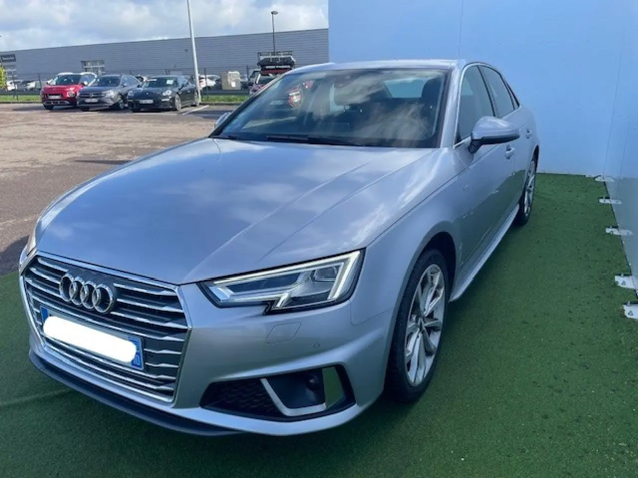 Audi A4 S line argent fleuret métal vue 3/4 avant droit avec phares LED et calandre chromée distinctive.
