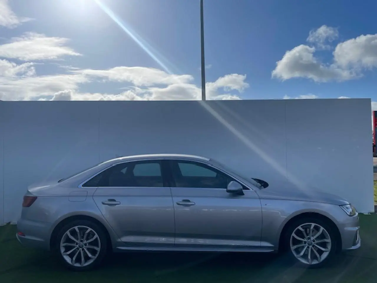 Audi A4 V 35 TFSI 2019 en profil côté gauche, finition argent métallisé avec jantes alliage 5 branches en Y.