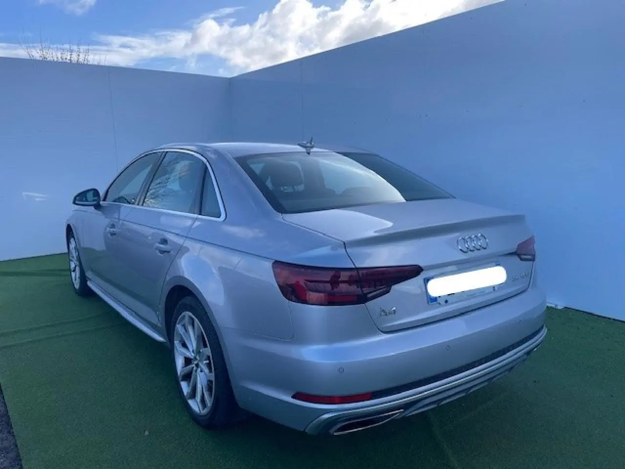 Audi A4 argent fleuret métal vue 3/4 arrière côté gauche avec jantes 5 branches et feux arrière LED