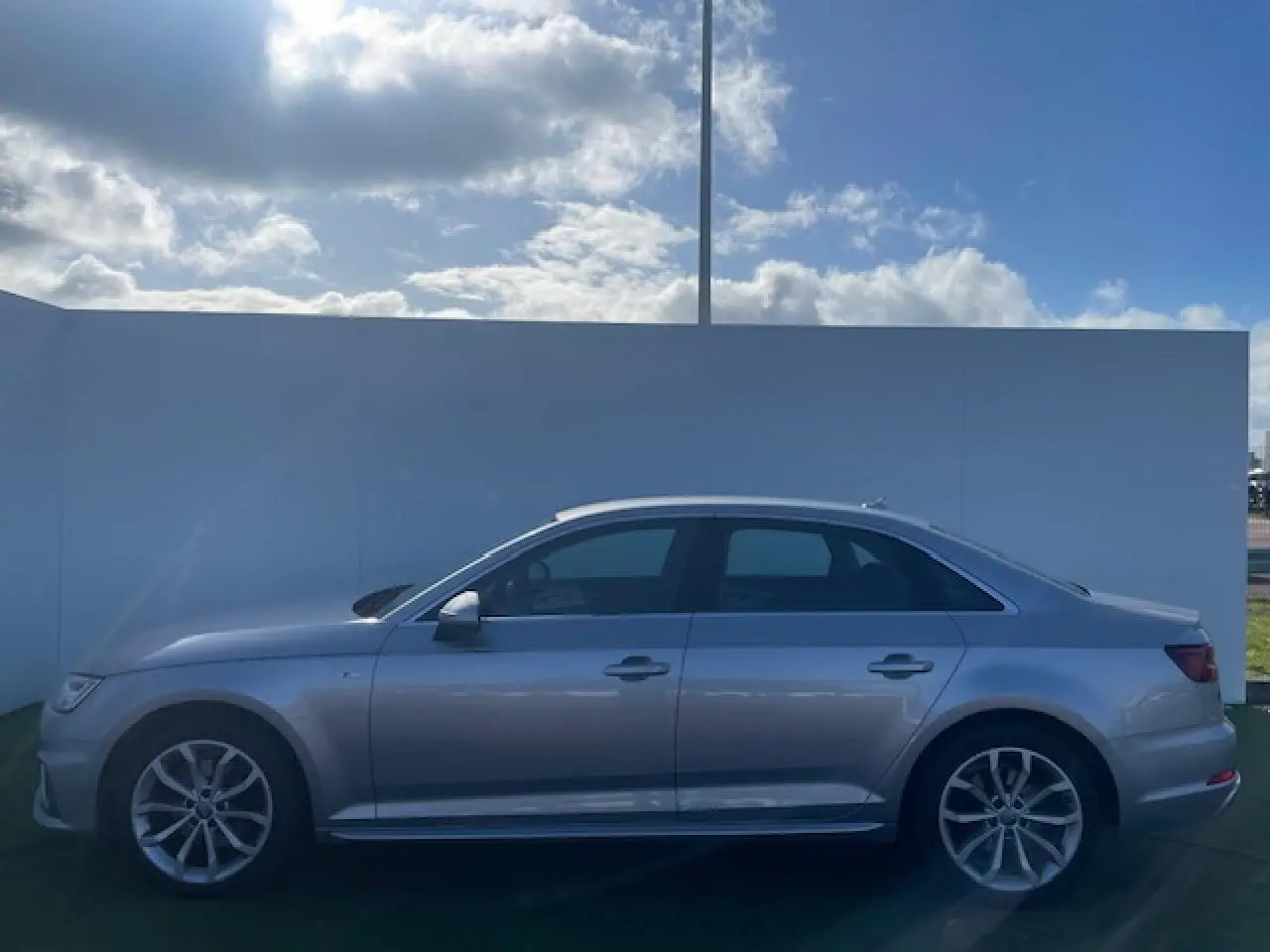 Audi A4 S line argent fleuret métal vue de profil côté gauche sur fond extérieur clair.