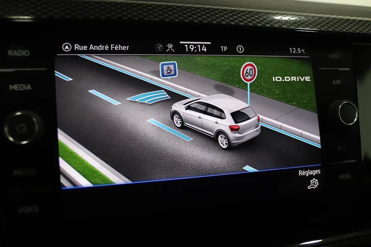 Affichage du Virtual Cockpit montrant une Volkswagen Polo noire en simulation de conduite avec indications de voie et limitation à 60 km/h
