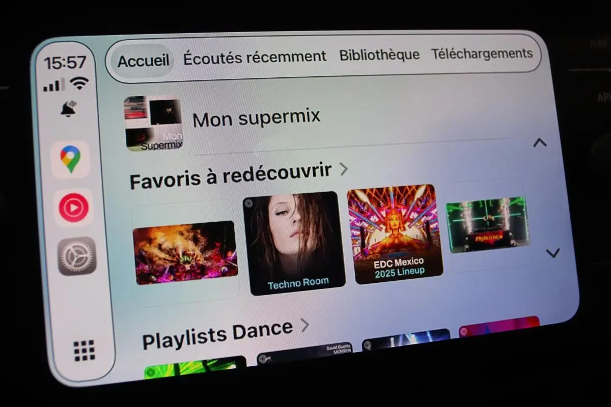 Écran tactile du système Apple CarPlay affichant une playlist musicale dans une Volkswagen Polo noire de 2022.