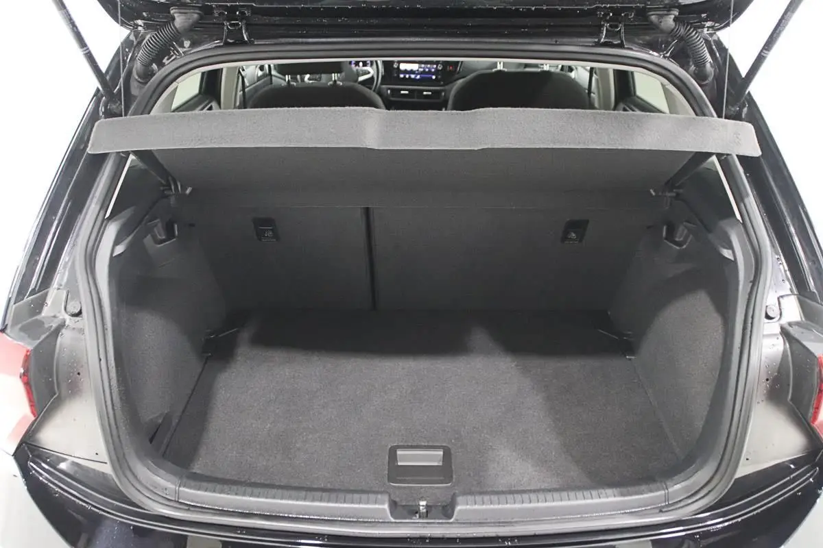 Coffre ouvert d'une Volkswagen Polo noire 2022, vue arrière montrant l'espace de chargement vide et l'intérieur sombre.