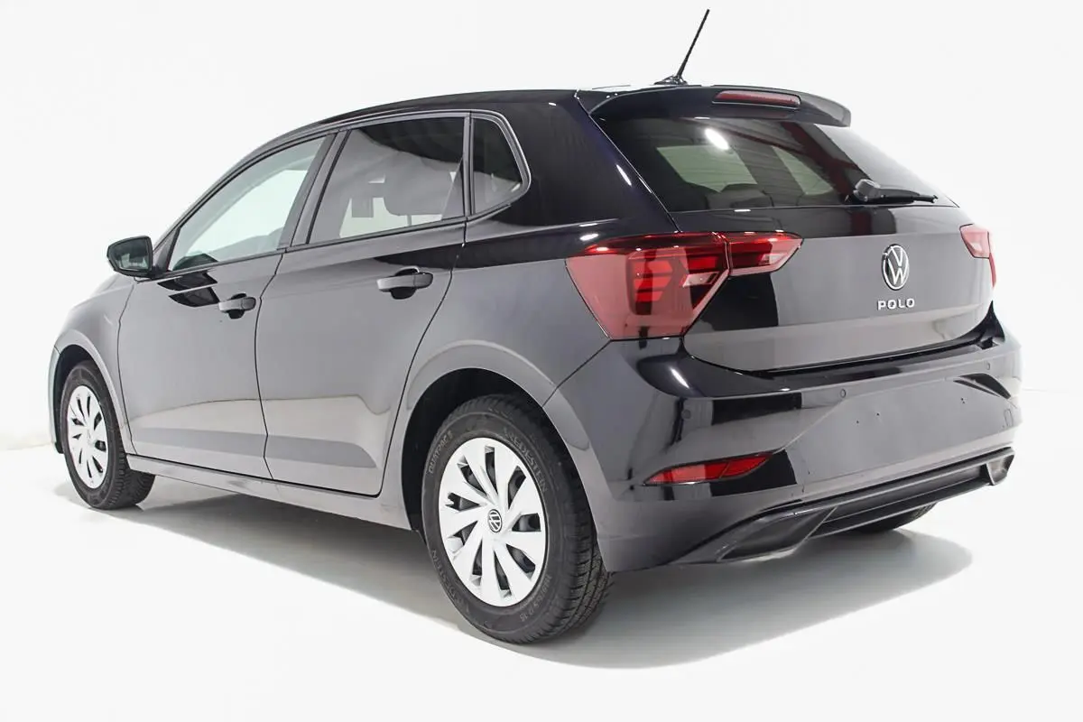 Volkswagen Polo noire vue en 3/4 arrière côté gauche, avec jantes blanches et feux arrière distinctifs.