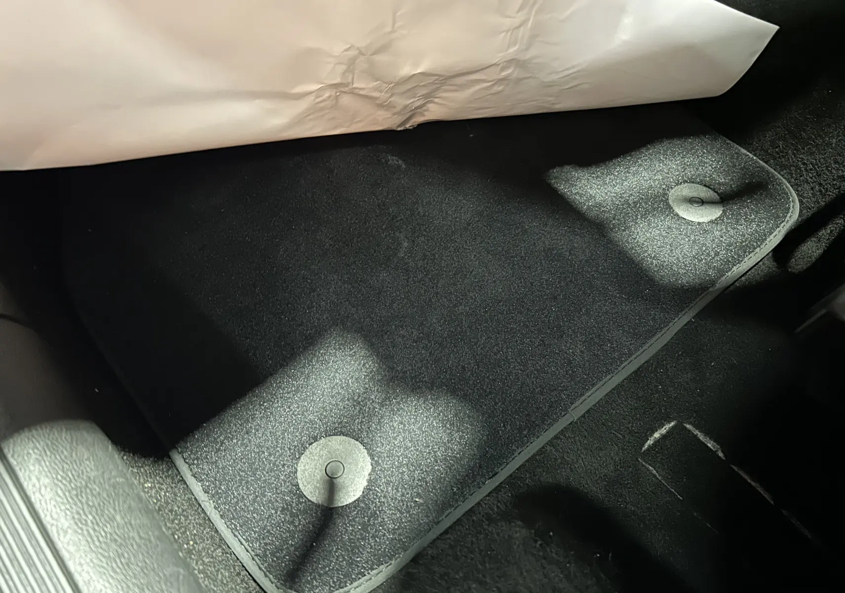 Vue rapprochée du tapis de sol noir côté conducteur d’une Volkswagen Polo 2022, avec fixation circulaire visible.
