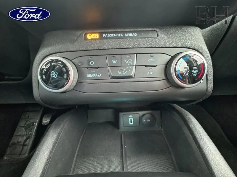 Vue rapprochée du tableau de bord central de la Ford Focus SW 2020, montrant les commandes de climatisation et l'indicateur airbag passager.