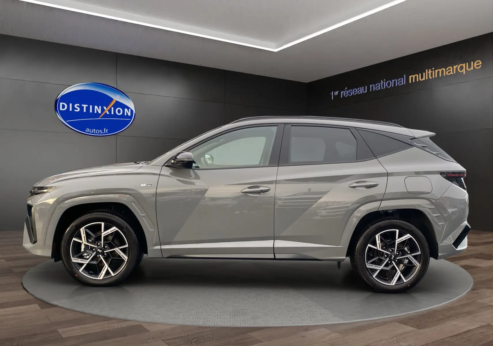 Vue de profil côté gauche d'un Hyundai Tucson 2026 gris Shadow avec jantes alu 19 pouces et badge N Line visible.