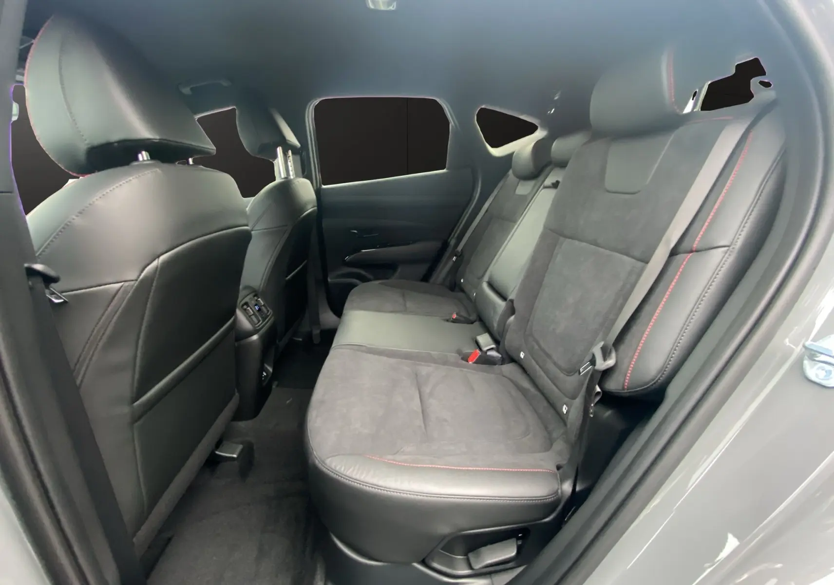 Vue intérieure côté droit des sièges arrière en cuir noir et alcantara avec surpiqûres rouges du Hyundai Tucson gris Shadow.