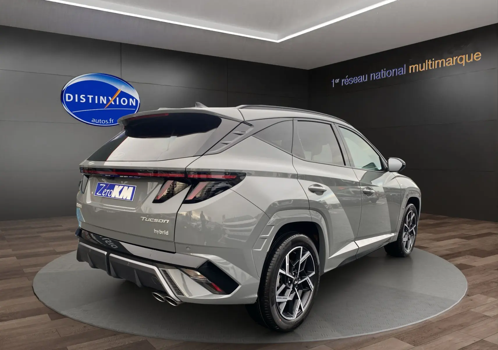 Vue 3/4 arrière droite du Hyundai Tucson hybride gris Shadow avec jantes alu 19 pouces et feux arrière LED distinctifs.