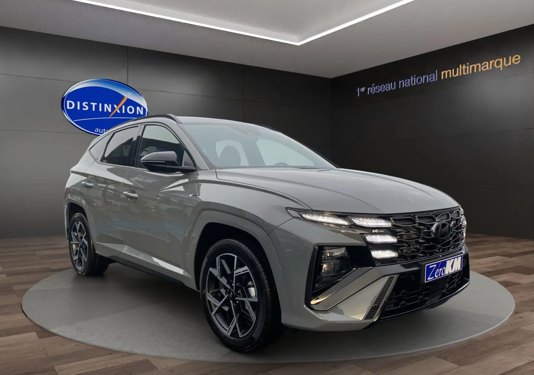 Vue 3/4 avant du Hyundai Tucson 2026 gris Shadow avec calandre N Line et jantes alu 19 pouces noires.