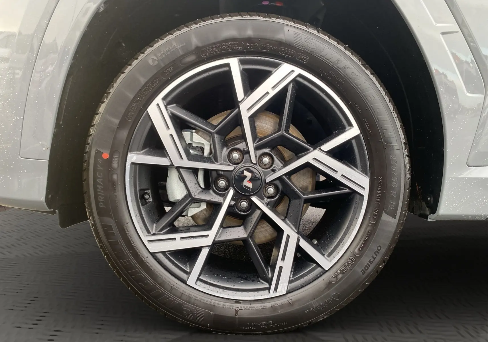 Gros plan sur la jante alu 19 pouces noire et argent du Hyundai Tucson 2026 en couleur Grey Shadow.