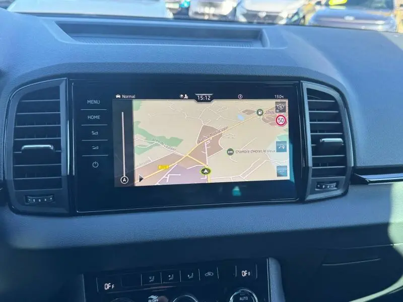 Vue rapprochée de l’écran tactile central du Skoda Karoq gris, affichant le GPS avec carte routière.