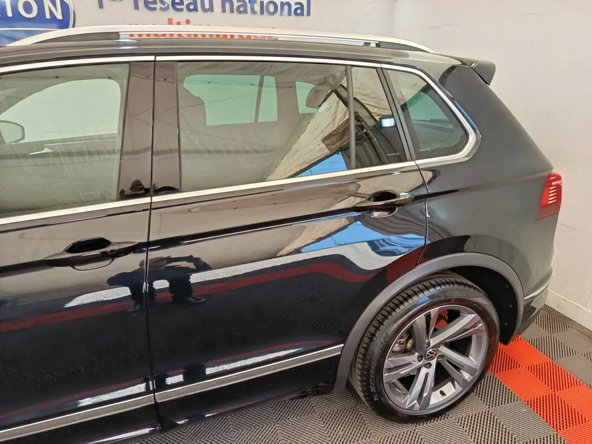 Vue latérale droite du Volkswagen Tiguan noir 1.4 eHybrid 2023 avec jantes alliage et détails chromés sur les portes.