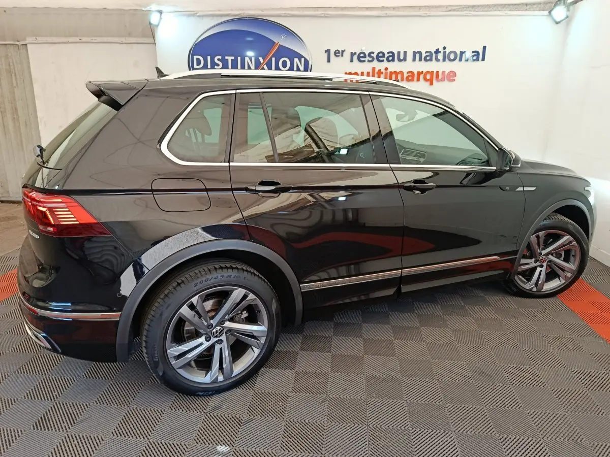 Vue de profil côté droit d'un Volkswagen Tiguan noir 1.4 eHybrid 2023 avec jantes alliage et toit ouvrant.