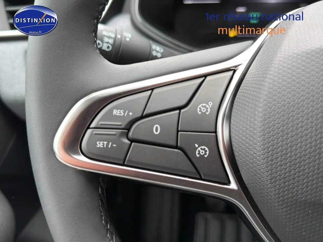 Gros plan sur les commandes de régulateur de vitesse au volant de la Renault Clio V Bleu iron, intérieur moderne.