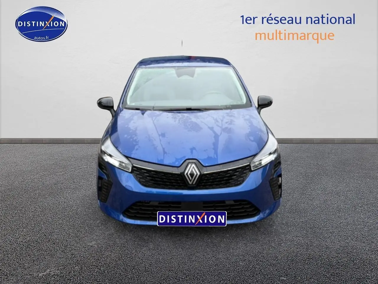 Vue avant d'une Renault Clio V bleu iron 2026 avec calandre noire et phares LED allumés.