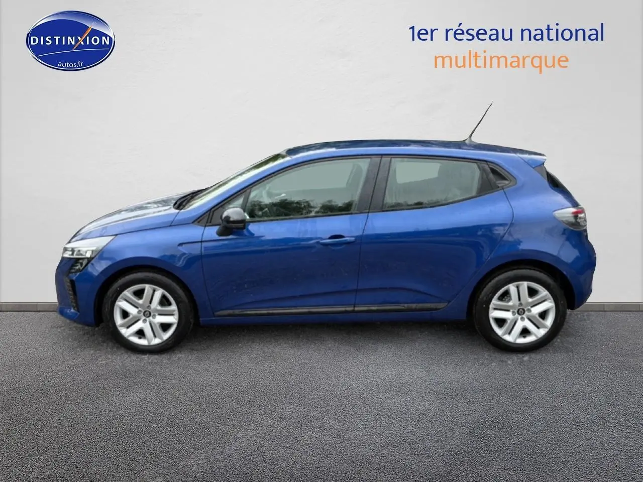 Profil côté gauche d'une Renault Clio V bleu iron 2026 avec jantes alliage et feux arrière LED visibles.