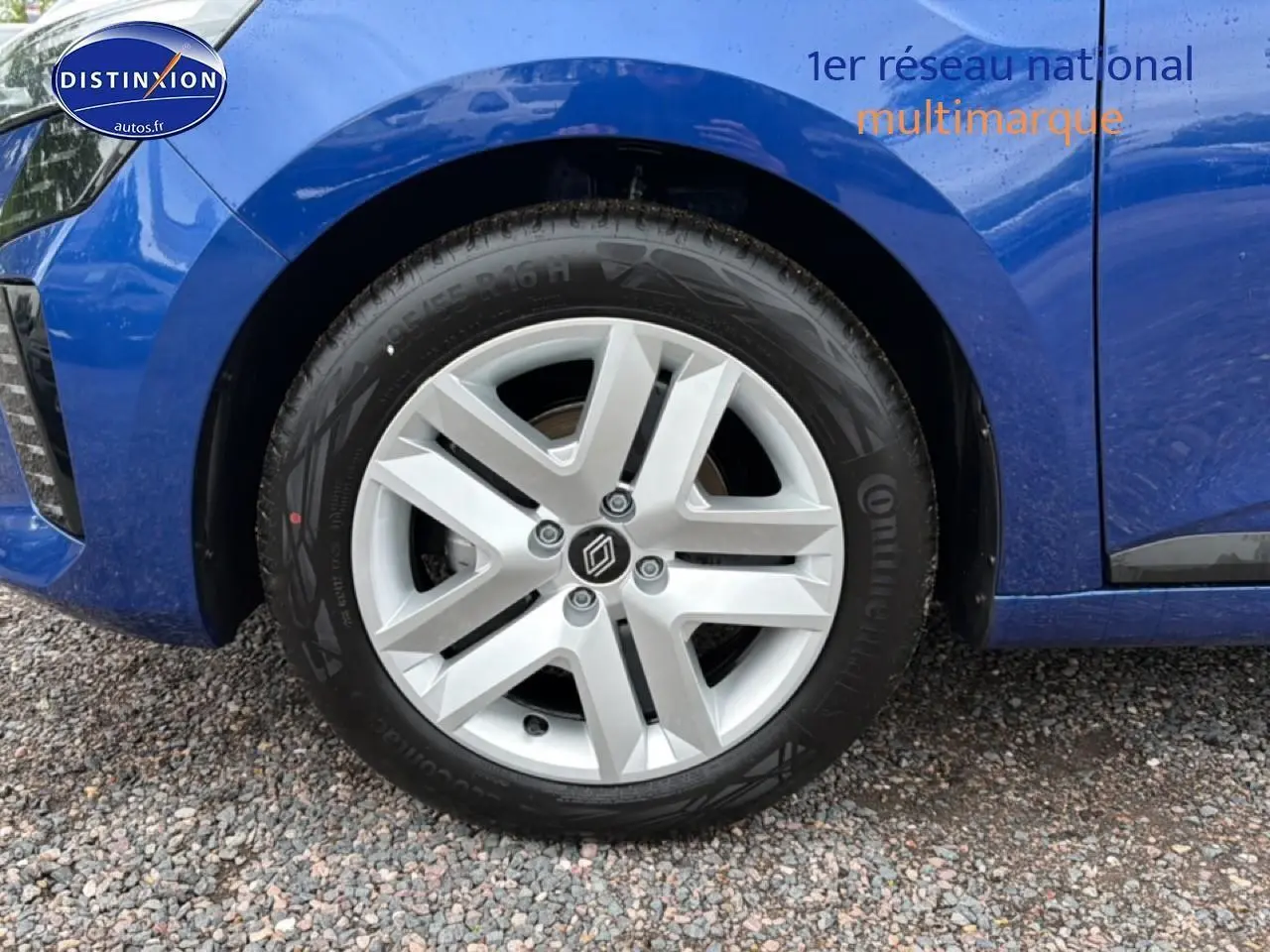 Gros plan sur la roue avant gauche d'une Renault Clio V bleu iron avec jante alliage et logo Renault central.