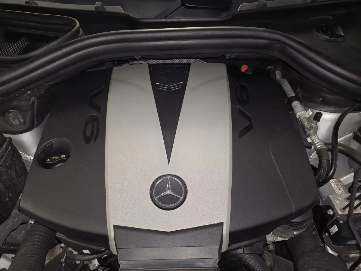 Vue rapprochée du moteur V6 gris et noir du Mercedes Classe M ML 350 BlueTEC 2014 avec logo étoile central visible.