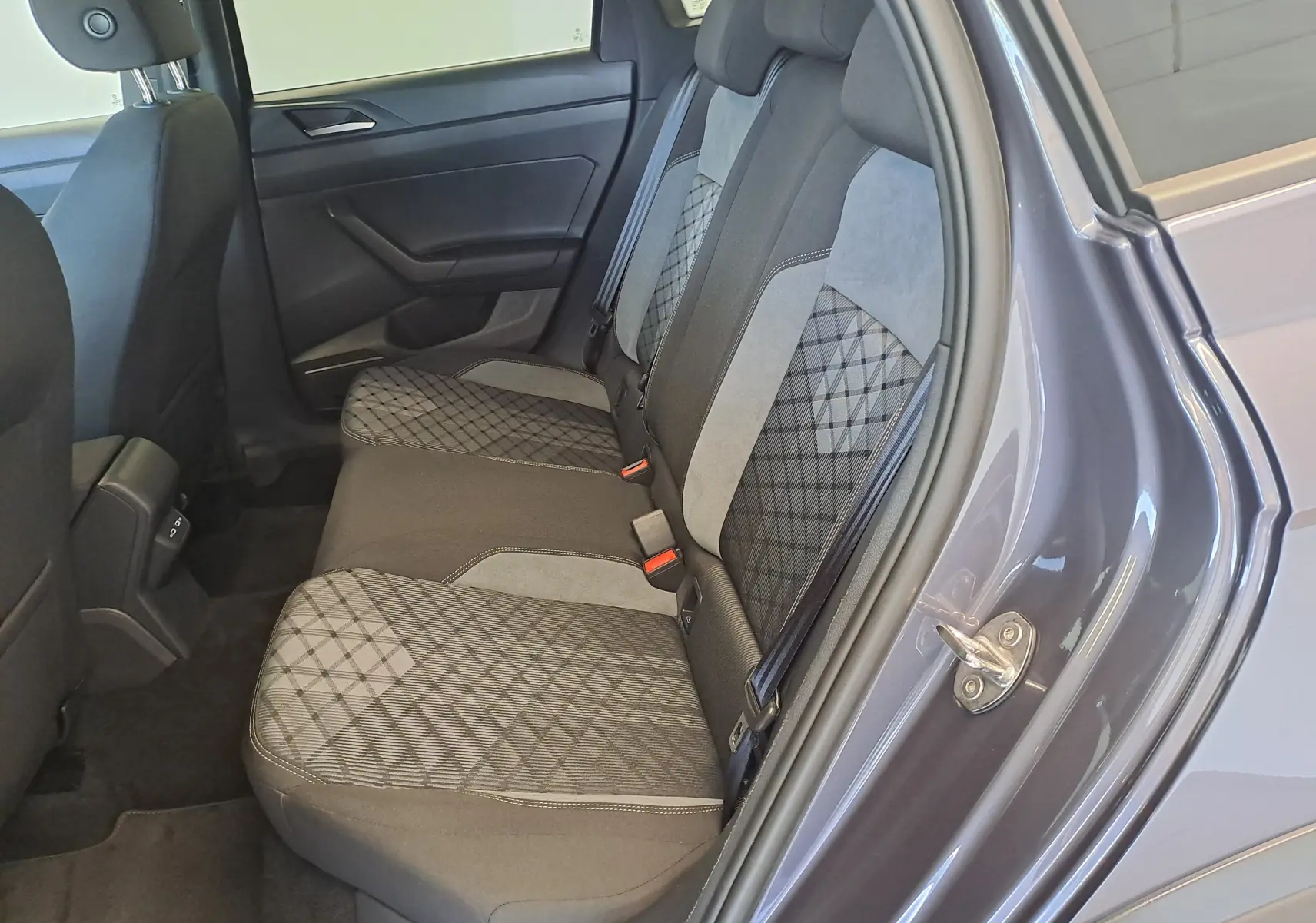 Vue intérieure côté droit des sièges arrière du Volkswagen Taigo gris cendre, avec sellerie tissu à motifs géométriques.