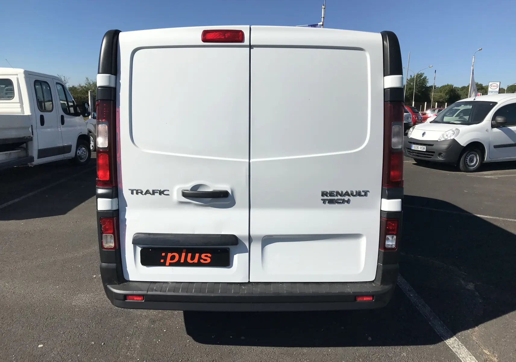 Vue arrière d'un fourgon Renault Trafic blanc avec portes battantes et logo Renault Tech visible.