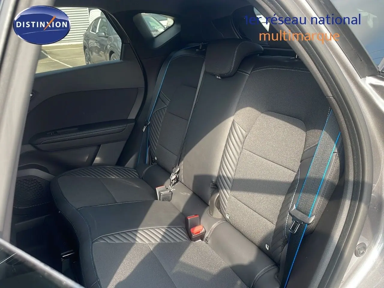 Banquette arrière en tissu et cuir noir avec surpiqûres bleues dans une Renault Captur gris cassiopée métal vue côté gauche.