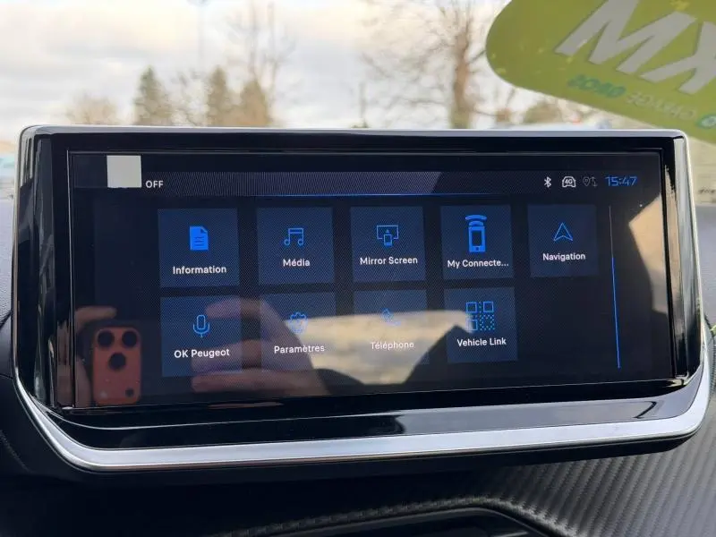 Écran tactile central affichant le menu multimédia dans l'habitacle du Peugeot 2008 bleu, vue de face rapprochée.