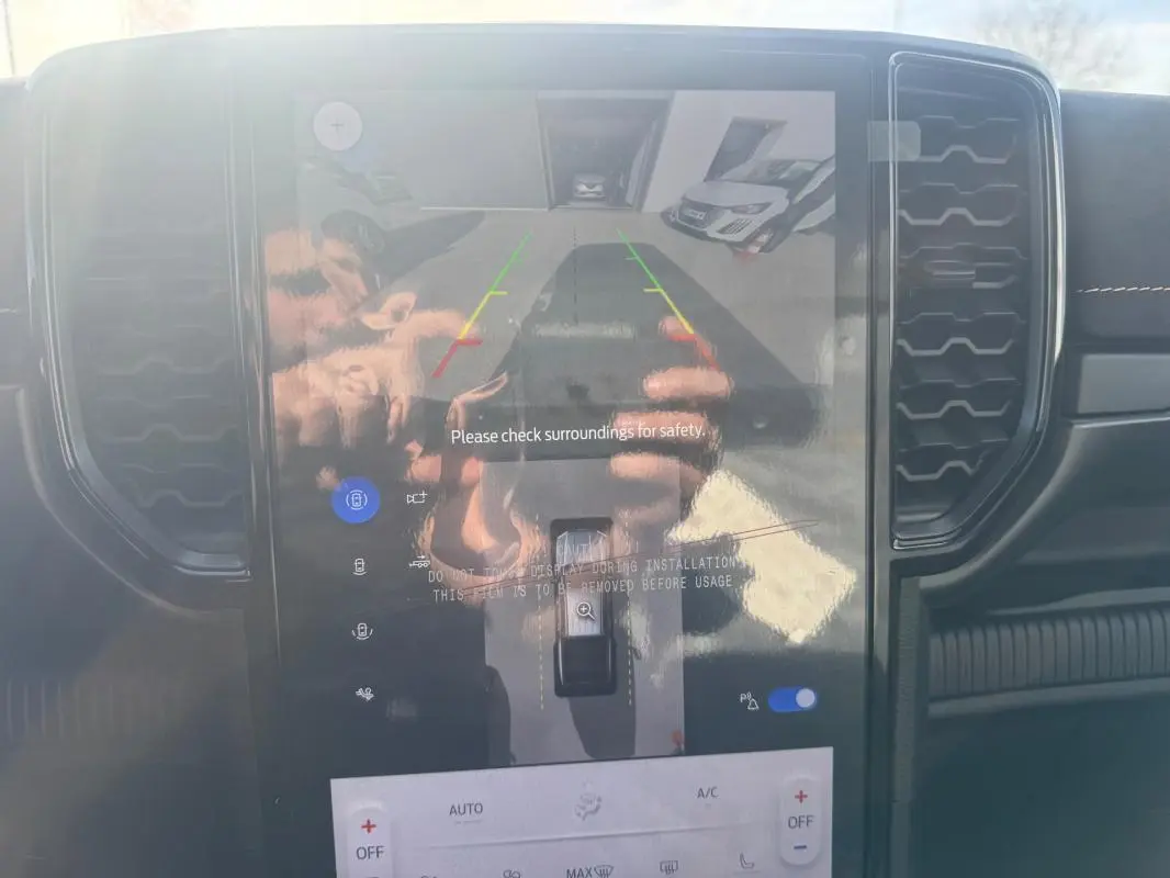 Vue intérieure du tableau de bord du Ford Ranger 2025, écran tactile affichant la caméra de recul avec commandes tactiles visibles.