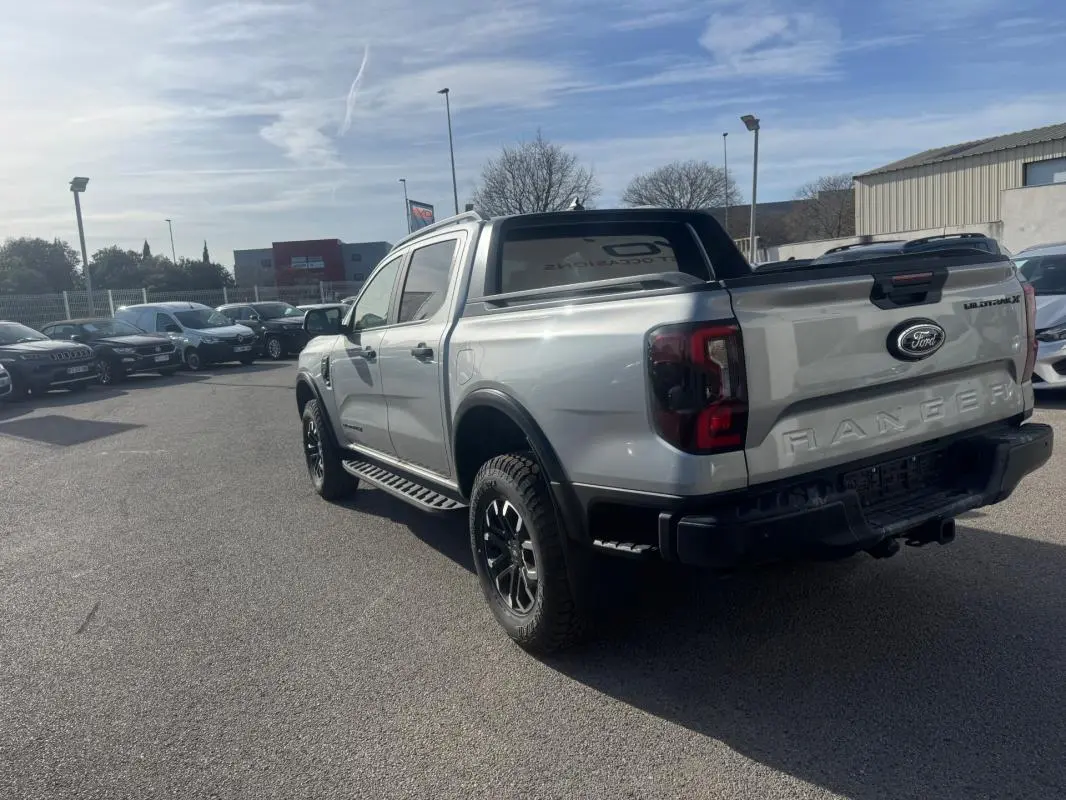 Vue 3/4 arrière droite d'un Ford Ranger gris 2025 avec jantes alliage noires et vitres surteintées.