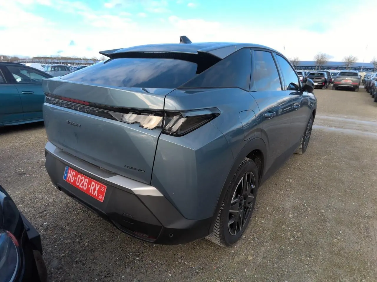 Vue 3/4 arrière droite d’un Peugeot 3008 hybride bleu clair avec feux arrière LED et toit noir brillant.