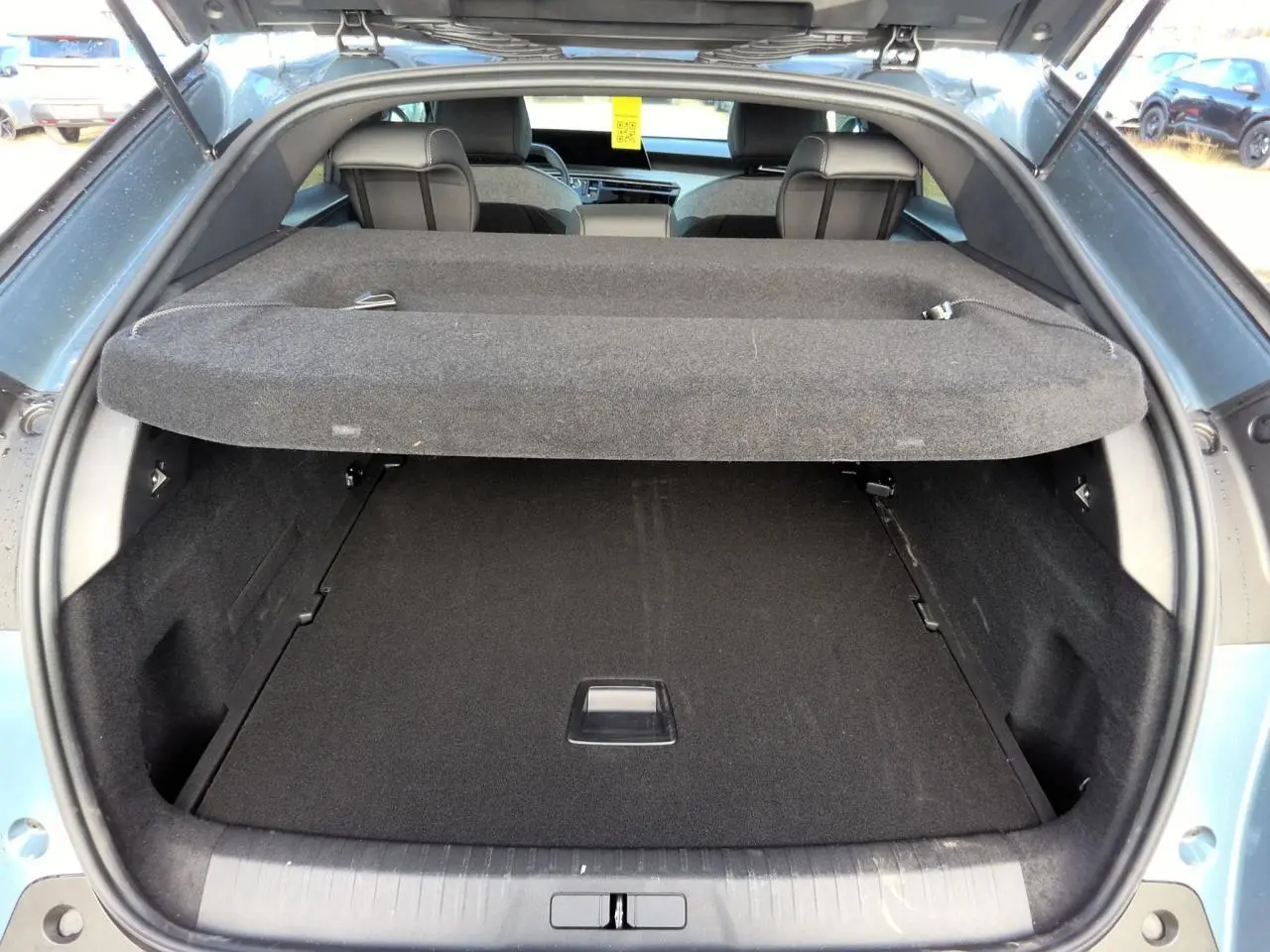 Coffre ouvert vu de l'arrière du Peugeot 3008 bleu clair, montrant l'espace de chargement et la plage arrière.