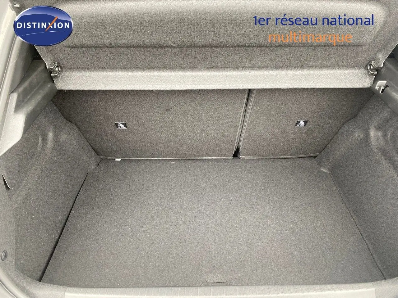 Coffre ouvert d'une Peugeot 208 Hybrid 145ch gris selenium metal, montrant un espace de rangement propre et spacieux.