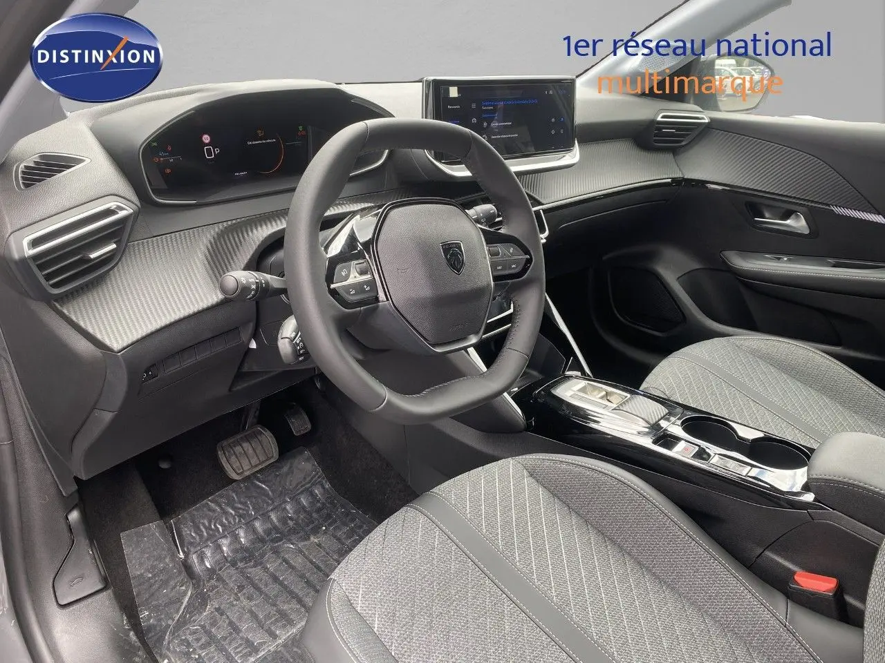 Vue intérieure côté conducteur du Peugeot 208 Hybrid 145ch Allure 2026, avec tableau de bord numérique et sellerie tissu gris.