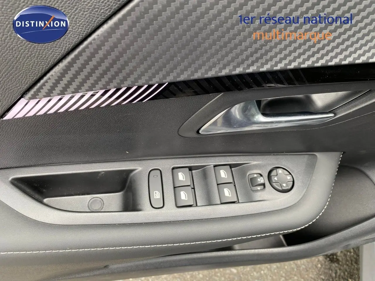 Détail de la porte côté conducteur de la Peugeot 208 Hybrid 145ch Allure 2026, avec commandes des vitres et insert décor carbone.