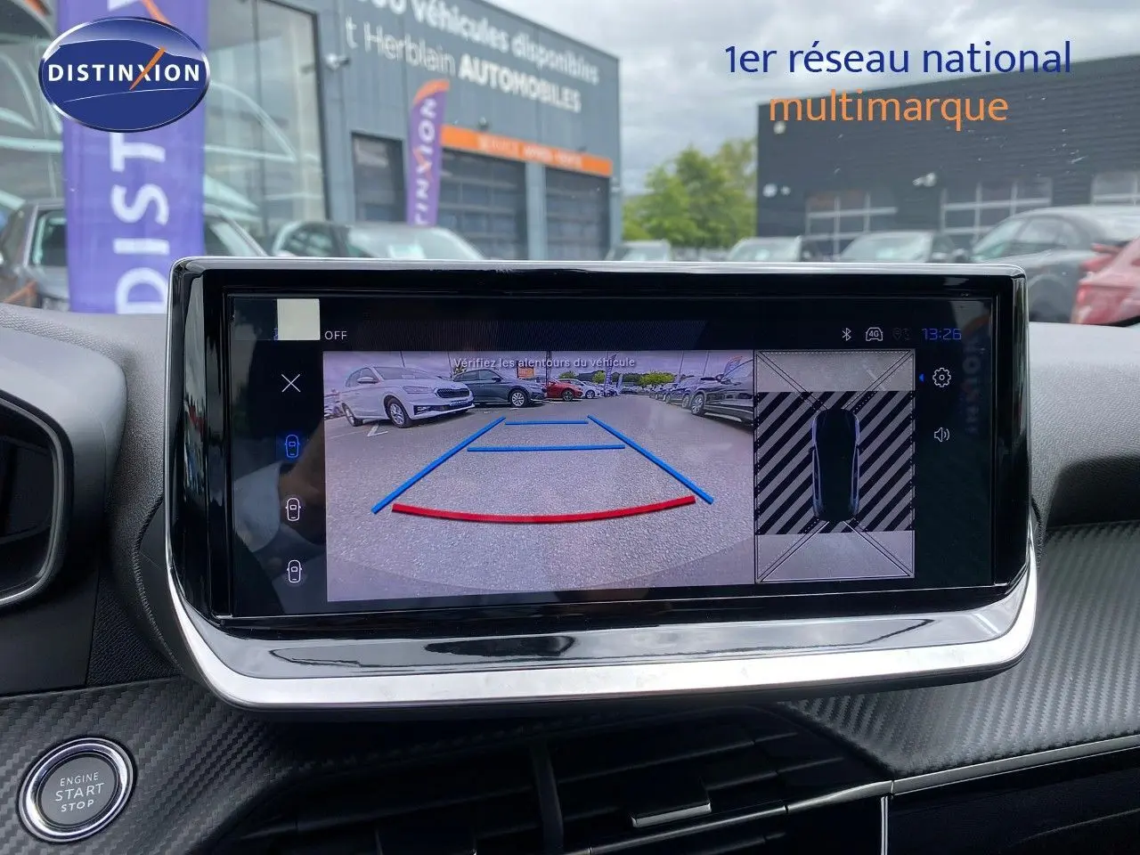 Écran central montrant la caméra de recul avec vue arrière et top-down d’un Peugeot 208 gris Selenium.