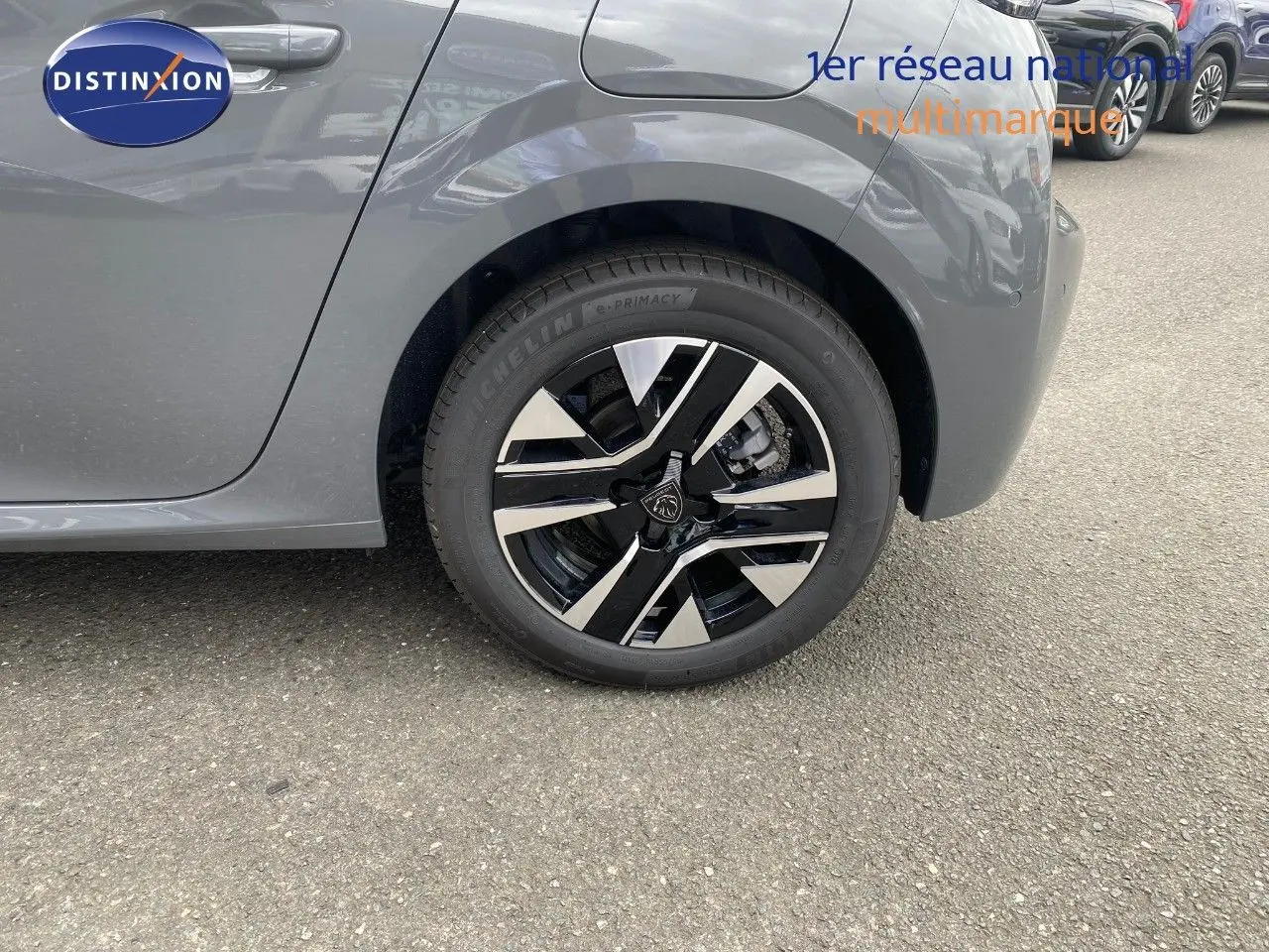 Gros plan sur la roue arrière droite d'une Peugeot 208 gris selenium métal avec jante alliage noire et argent.