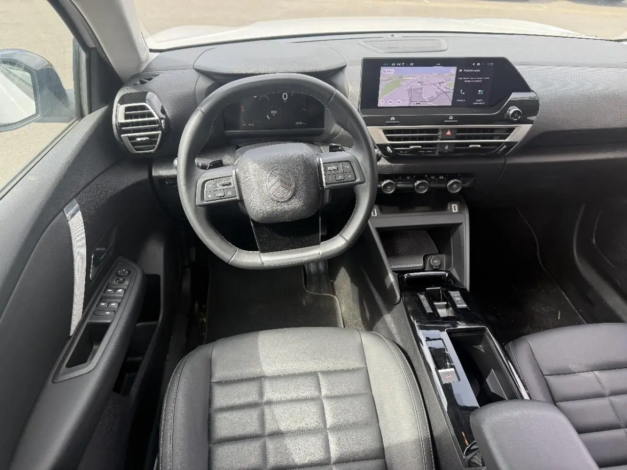 Vue intérieure frontale du poste de conduite de la Citroën C4 2025 avec tableau de bord numérique et écran tactile central.