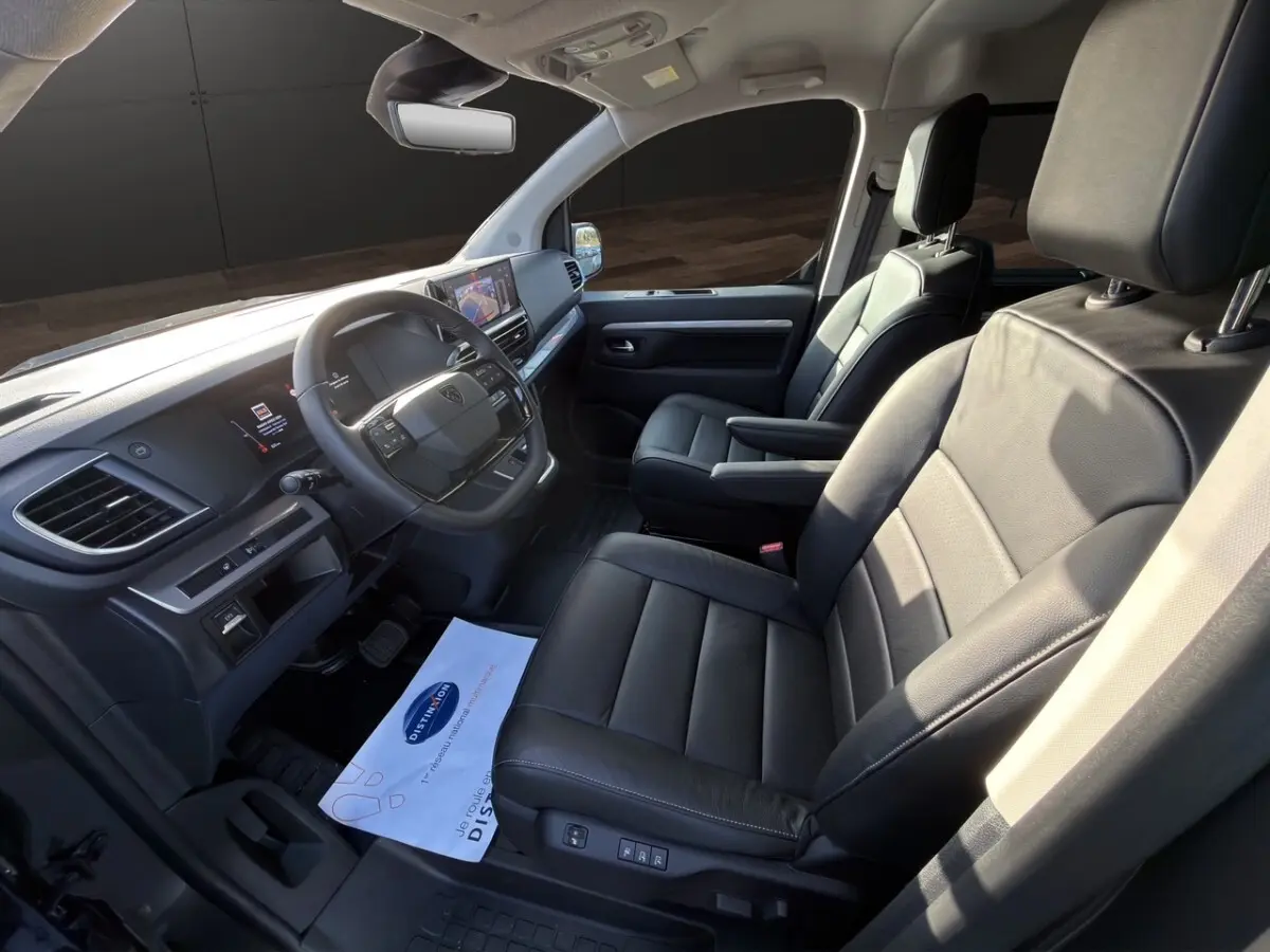 Vue intérieure côté conducteur du Peugeot Expert Fourgon 2026, sièges en cuir noir et tableau de bord moderne avec écran tactile.