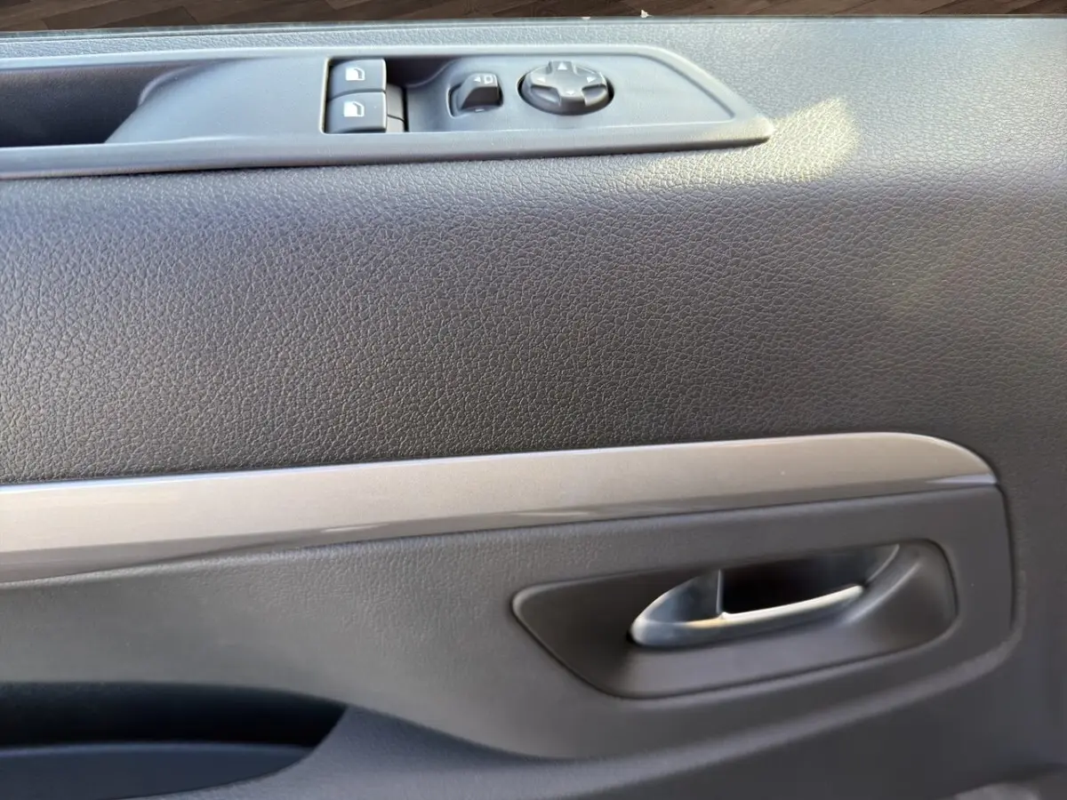 Gros plan sur la porte intérieure côté conducteur du Peugeot Expert Fourgon gris foncé, avec commandes électriques et poignée argentée.