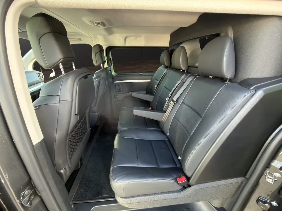 Vue intérieure côté droit du Peugeot Expert Fourgon XL 2026, sièges arrière en cuir noir avec accoudoirs.