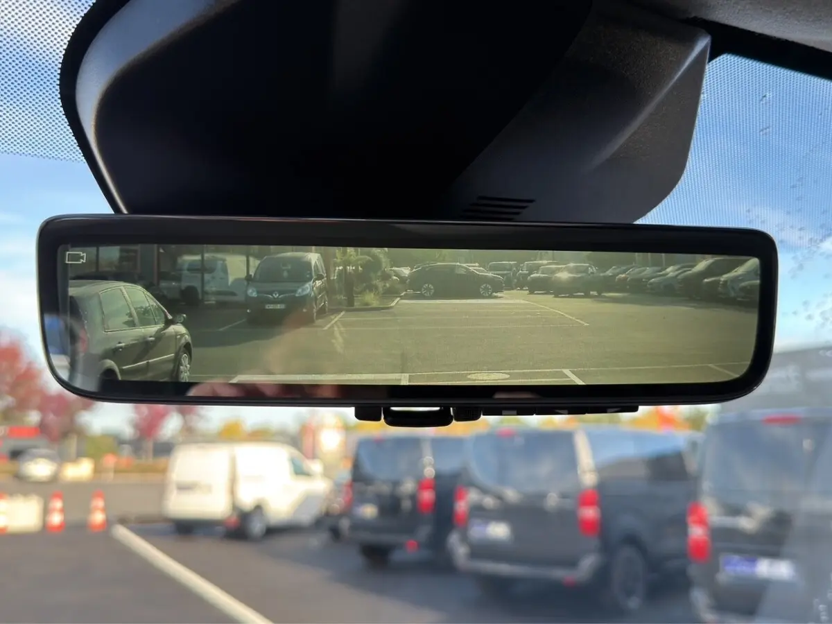 Vue du rétroviseur intérieur numérique du Peugeot Expert Fourgon gris foncé, affichant le parking arrière avec plusieurs véhicules.