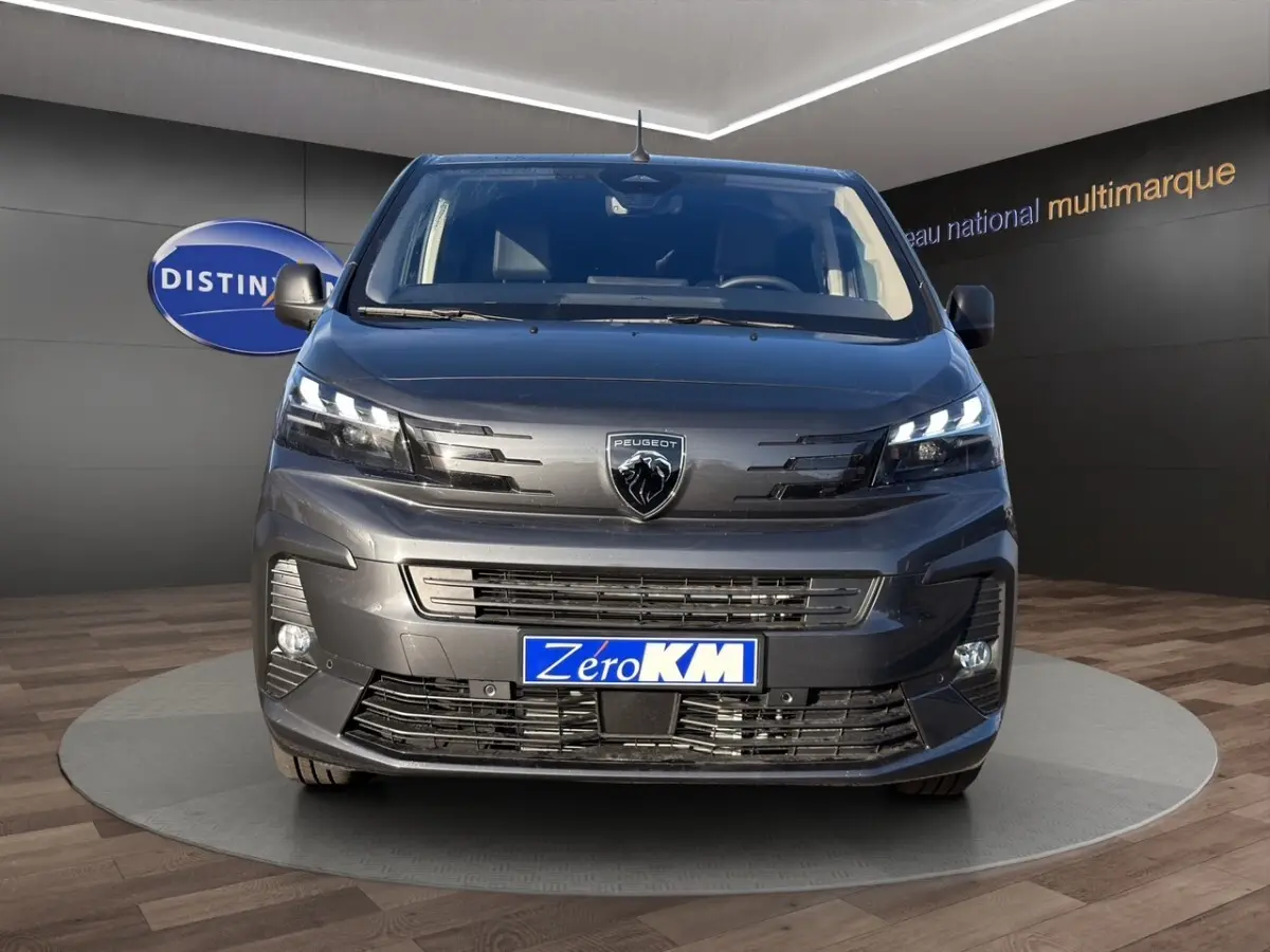Vue de face du Peugeot Expert Fourgon gris foncé avec phares LED et logo lion central bien visible.