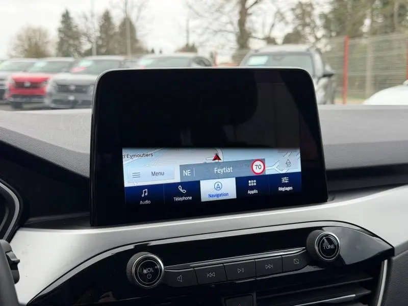 Écran tactile central du Ford Kuga 2024 affichant la navigation, avec commandes audio et téléphone en dessous, intérieur gris et noir.