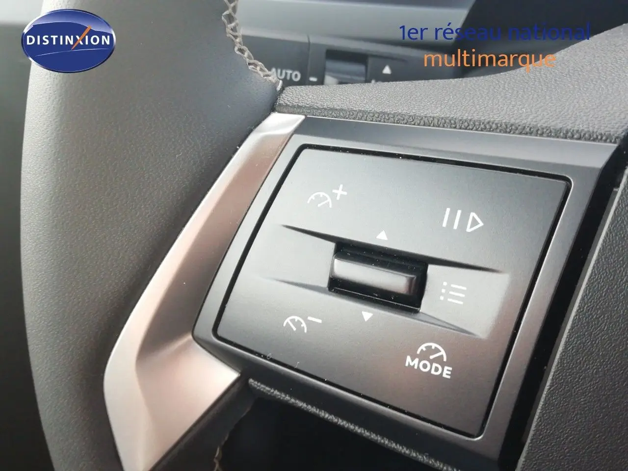 Gros plan sur les commandes au volant noir de l'Opel Frontera 2025, mettant en valeur les fonctions de régulateur et mode.
